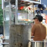 A local vendor prepares food at a street stall in bustling Ho Chi Minh City, Vietnam.